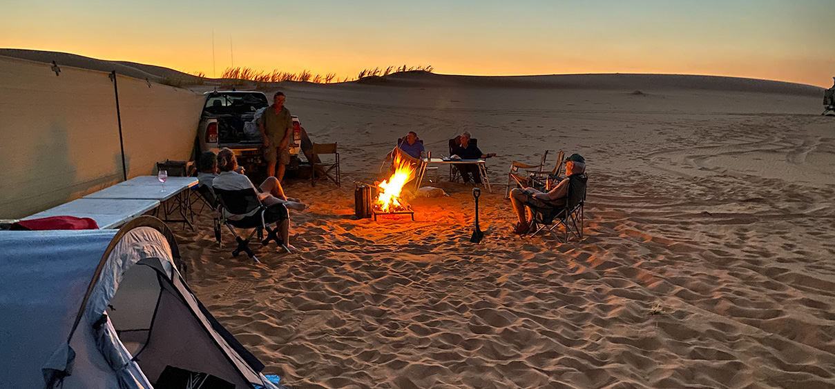 view of the campsite with a windbreak and a campfire
